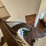 Dark wood luxury curved staircase with elegant handrail and custom craftsmanship
