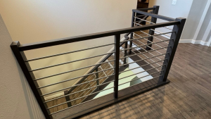 Staircase with modern cable railing and dark wood frame.