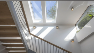 Staircase illuminated by overhead skylights allowing natural light to brighten the stairwell.
