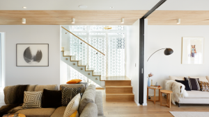 Staircase with glass panels in a bright white room allowing natural light to flow through the stairwell.