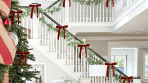 Holiday staircase decorated with festive ribbon bows tied around the newel posts, adding a touch of color and charm to the seasonal decor.