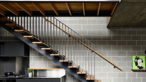 Industrial staircase style featuring wood treads and a matte black railing