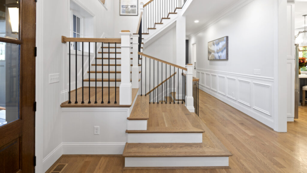 Custom stairs featuring light wood treads and metal balusters, crafted with clean lines and fine detail