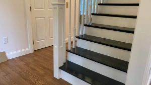Modern staircase with dark wood stair stain, white risers, and white balusters in a residential home renovation