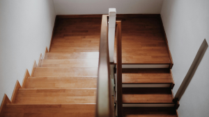 Wood staircase with contrasting stain tones and natural light, showing how lighting affects staircase color and finish.