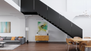 Modern black steel staircase with minimalist design in a bright open-plan home featuring white walls and wood flooring.