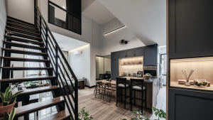 Dark wood staircase with black railings against white walls in an open-plan living space.